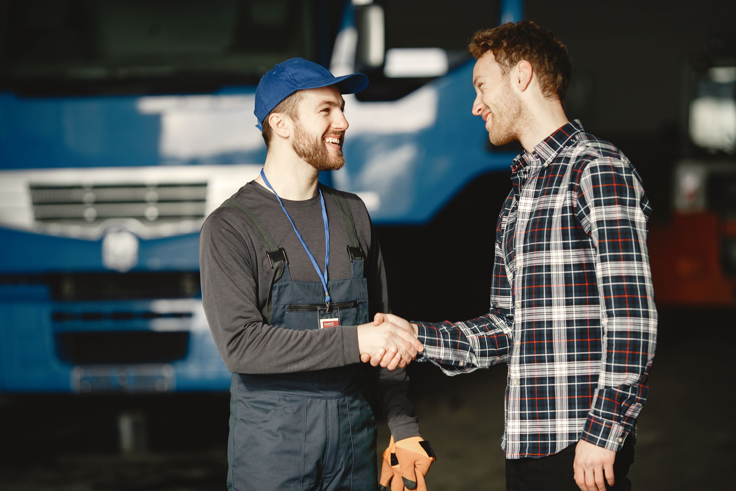 Two transportation professionals greeting each other beside a truck