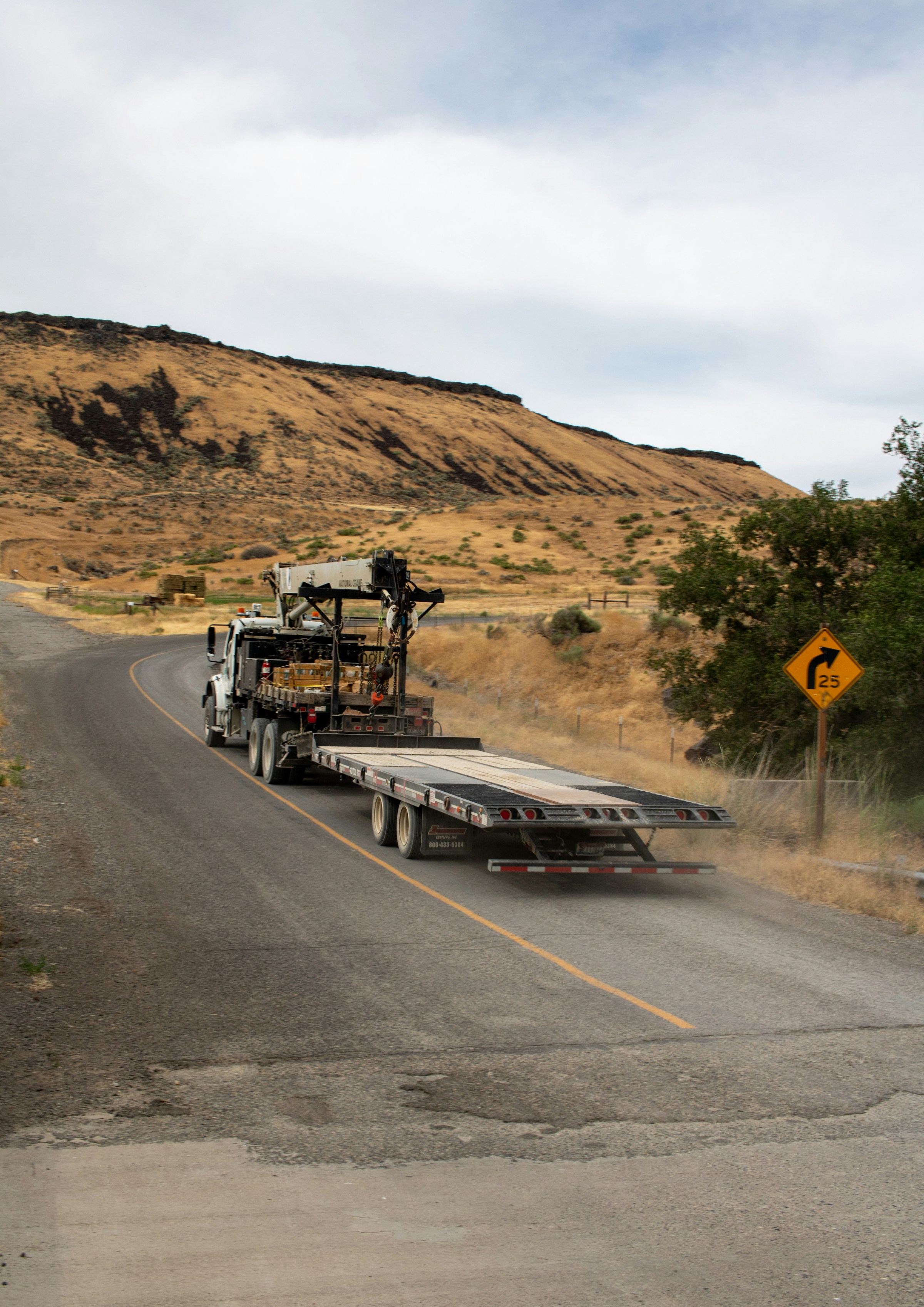 A real flatbed truck traveling a rural road in Idaho